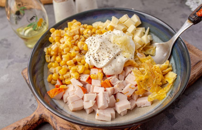 1. Этап. Салат с яичными блинчиками, копчёной курицей и кукурузой: Майонез желательно использовать домашний. Выложите в салатник, добавьте чеснок пропущенный через пресс, соль и черный молотый перец по вкусу. Перемешайте салат.