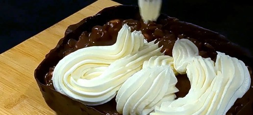 1. Этап. Шоколадный десерт с нежным творожным кремом: Нарежьте арахис и добавьте его в остатки шоколада. Чтобы снова растопить остатки шоколада рекомендую использовать метод - интервального нагревания в микроволновке (по 5-10 сек) добавив немного растительного масла. Получившеюся шоколадную массу с орехами выложите сверху на бисквит в шоколадной форме. Сверху покройте второй частью подготовленного крема оставив немного крема для украшения.