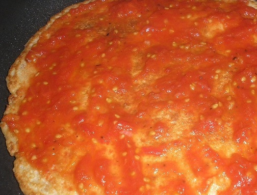 1. Этап. Быстрая пицца из батона: Теперь вам необходимо собрать пиццу. Для этого корж оставьте на сковороде, где он готовился. Сверху выложите пасту из томатов. Поперчите и посолите блюдо по вашему вкусу.