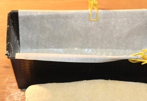 1. Этап. Хлеб на картофельном отваре: 7. Застелить формочку (26*11 см) пергаментом. Смазать бумагу растительным маслом и немного припылить дно мукой. Тесто размять и сформировать прямоугольник. Затем скатать. Выложить тесто в форму и накрыть пленкой или прозрачным пакетом.