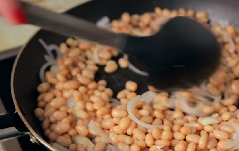 1. Этап. Тефтели в томатном соусе (вегетарианские): 4. Фасоль промойте и обжарьте на небольшом количестве растительного масла с нарезанным полукольцами луком и чесноком. Посолите и поперчите ее по вкусу.