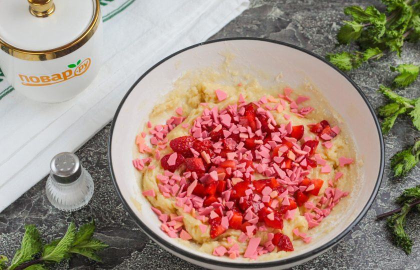 1. Этап. Печенье с клубникой и шоколадом: Промойте клубнику и удалите хвостики. Нарежьте мелкими кубиками и всыпьте в емкость с тестом. Можно приобрести шоколадную крошку (у меня — розовый шоколад), можно натереть обычный на крупной терке. Добавьте его тоже в емкость и перемешайте.