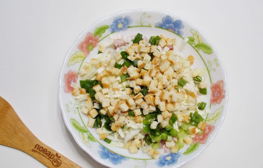 1. Этап. Салат с ветчиной, кукурузой и сухариками: Зеленый лук мелко нарежьте. Выложите в салат. Добавьте сухарики.