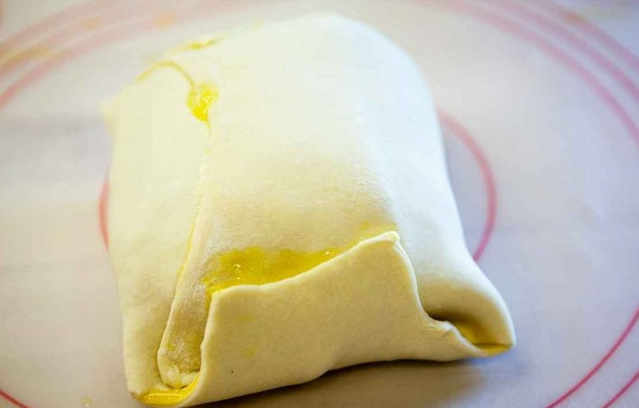 1. Этап. Говядина Веллингтон с грибной пастой: 8. Заверните мясо в слоеное тесто, постарайтесь сделать это в 1 слой, не нужное тесто обрежьте.