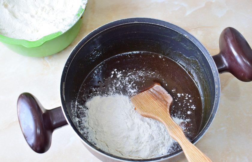 1. Этап. Медовик с клубникой и сметанным кремом: Постепенно всыпайте муку и замешивайте тесто.