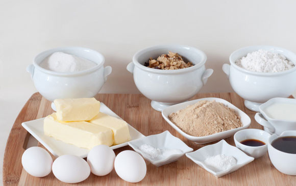 1. Этап. Вкусный торт с орехами: 1. Подготовим ингредиенты. Для теста смешаем сначала все сухие компоненты - муку, сахар, ванилин, соду, соль и ванильный сахар. Добавим масло комнатной температуры, порубленное кусочками, и руками перемешаем все в крошку. Дальше добавим молоко, яйца, кленовый сироп, и перемешаем до однородности. Последними добавим орехи, делим тесто на три части.