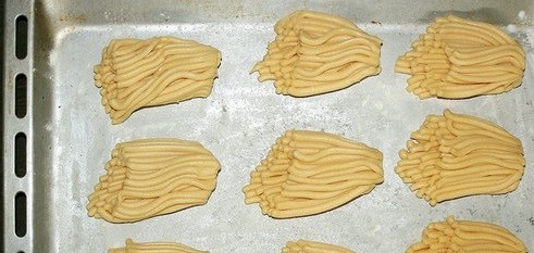 1. Этап. Печенье через мясорубку с маргарином: Прокручиваем и каждые 5-7 сантиметров срезаем ножом. Таким образом у вас должно получится печенье как на фотографии. Заполняем противень печеньем и отправляем в духовку запекаться на 35-40 минут.