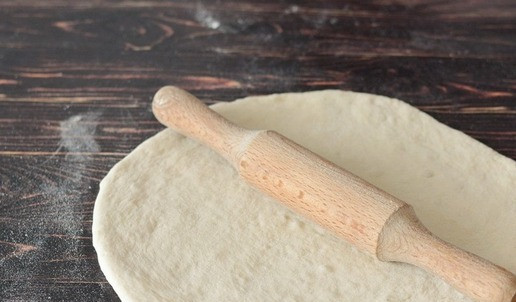 1. Этап. Рогалики с копчёной грудинкой и сыром: Подпылите стол мукой и раскатайте тесто в круг диаметром около 35 см.