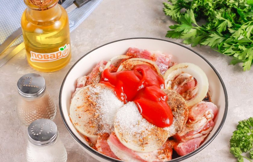 1. Этап. Шашлык из свинины под кисло-сладким соусом: Свиной подчеревок или часть свиной шеи промойте в воде, срежьте кожу либо пленки и жилы. Нарежьте порционными кусочками и выложите в глубокую емкость. Очистите и промойте репчатый лук, нарежьте его кольцами. Добавьте в емкость вместе со всеми приправами, специями и соусами.