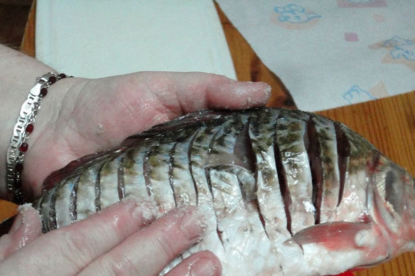 1. Этап. Рыба по-китайски: Рыбу почистить, выпотрошить, вымыть. Обсушить бумажными полотенцами и сделать неглубокие поперечные надрезы на тушке. Натереть солью.