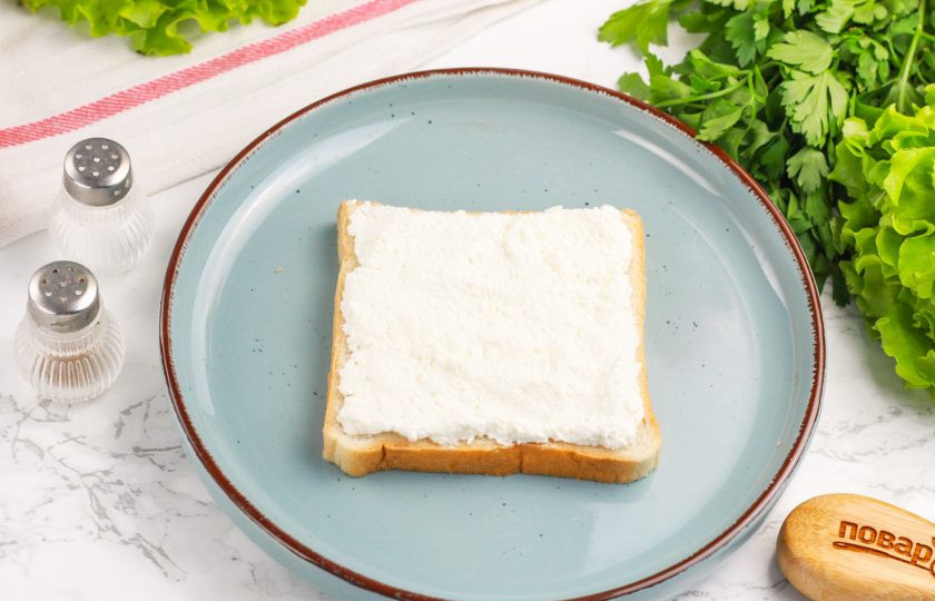 1. Этап. Сэндвич с креветками: Подготовьте тостовый хлеб и обмажьте его творожным сыром.