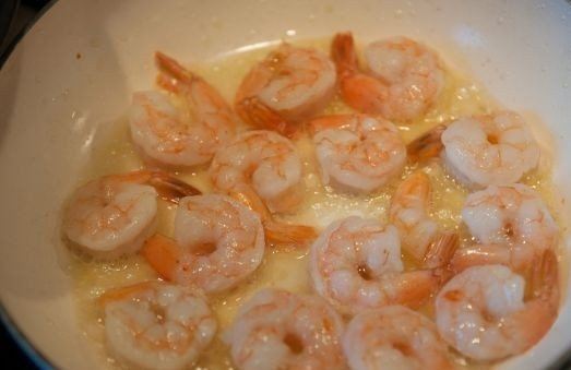 1. Этап. Салат из кальмара и креветок: 4. На сковороде разогрейте растительное масло и обжарьте чеснок. Как только он станет коричневым, аккуратно снимите его с огня. Выложите в масло креветки. Обжаривайте, помешивая, на среднем огне.