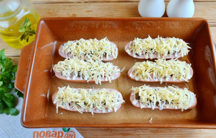 1. Этап. Сардельки, фаршированные сыром и грибами: Посыпьте щедро тертым сыром и отправьте в горячую духовку на 15-20 минут, температура — 200 градусов.