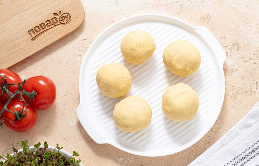 1. Этап. Гордитас с фасолью: Разделите тесто на равные шарики примерно по 50-60 грамм. Каждый присыпьте мукой, и зажмите между двух листов пергамента для выпечки. Раскатайте толщиной до 5-6 мм. Пока работаете с одним шариком теста, остальные прикройте пленкой, чтобы не подсыхали.