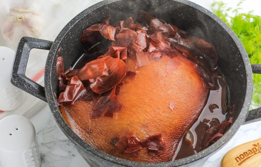 1. Этап. Щековина свиная в луковой шелухе: Отварите щековину примерно 40-45 минут на умеренном нагреве. На середине варки переверните ее кожей верх и накройте емкость крышкой.