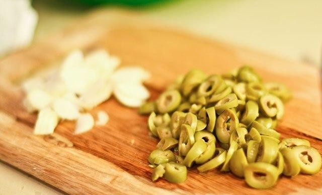 1. Этап. Паста с фисташками и оливками: Нарезаем наши оливочки. Я обычно режу плоскими дольками, но можно на половины или четвертины резать - кому как больше нравится, на вкусе это сильно не отражается. На тоненькие пластины нарезаем чеснок.