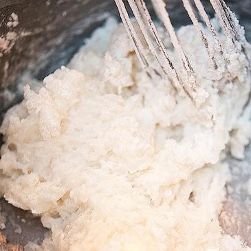 1. Этап. Бразильские сырные булочки: 2. Добавить муку, постоянно помешивая венчиком, пока тесто не станет пластичным и его можно будет замесить руками. Не перемешивайте слишком долго, чтобы тесто не стало твердым. Добавить столько муки, сколько необходимо для достижения нужной консистенции.