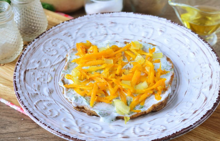 1. Этап. Печеночный торт без майонеза: Печеночные коржи смажьте йогуртовым соусом и выложите обжаренные овощи.