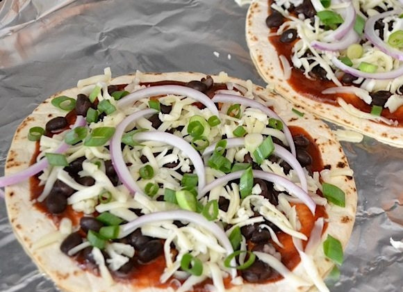 1. Этап. Мини-пицца из тортильи: 5. Нарежьте мелко зеленый лук и тонкими полукольцами красный. Выложите оба вида лука.