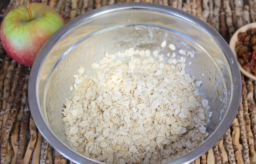 1. Этап. Овсяное печенье с изюмом и яблоками: Насыпаем в миску овсяные хлопья, перемешиваем и оставляем минут на 5.