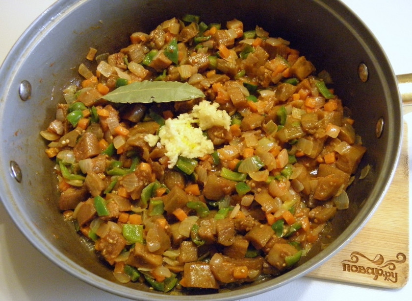 1. Этап. Икра из баклажанов кусочками: Добавьте чеснок, лавровый лист. Протушите еще минут 5. Пробуйте икру на готовность и соль. Если овощи выделяют мало сока, можно влить чуточку воды.