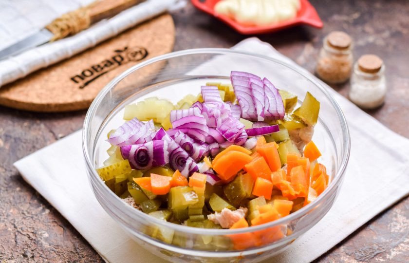 1. Этап. Мясной салат на Новый год: Вареную морковь нарежьте небольшими кубиками и добавьте в салат. Также нарежьте мелкими кубиками красный лук, добавьте к остальным ингредиентам.