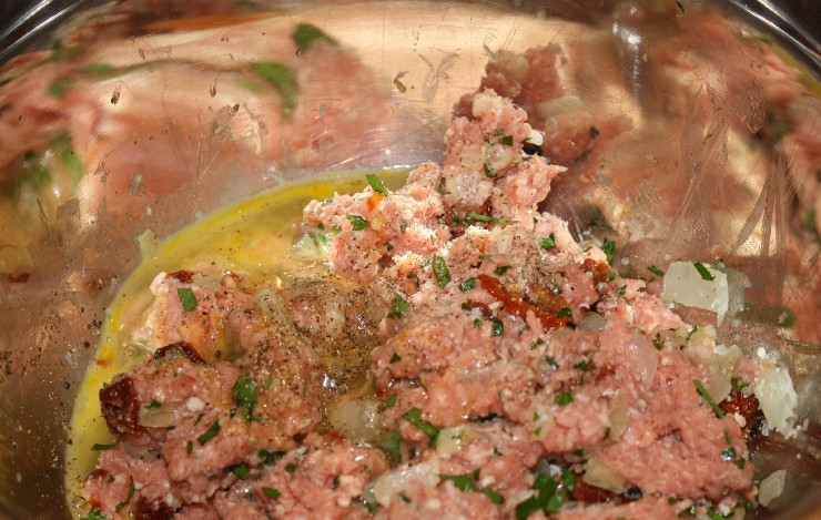 1. Этап. Паста с фрикадельками в томатном соусе: Выкладываем в глубокую миску фарш, остывший бекон с луком, разбиваем яйца, добавляем измельченный сыр, панировочные сухари, половину от всей петрушки (измельченной), нарезанные мелко вяленые помидоры, соль и перец по вкусу. Тщательно перемешиваем массу до однородности.