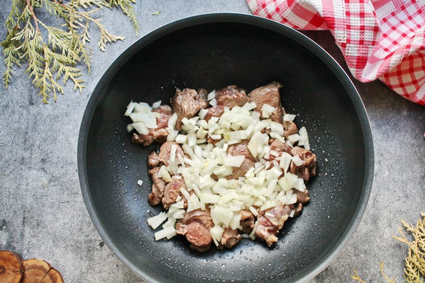 1. Этап. Эсик флейш: Репчатый лук мелко порежьте и выложите в казан. Обжаривайте все еще 4 минуты, перемешивая.