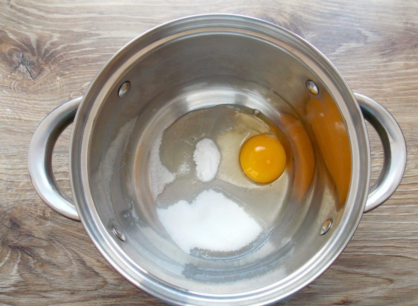 1. Этап. Хворост Ажурный: В глубокую миску разбейте яйцо, добавьте сахар, соль, соду и перемешайте до однородности.