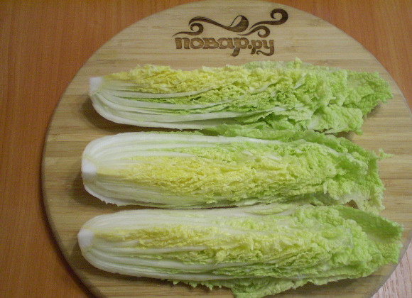 1. Этап. Засолка пекинской капусты по-корейски: Капусту вымойте, дайте воде хорошо стечь. Снимите верхние листья (они не понадобятся). Сам кочан разрежьте вдоль на 4 части.