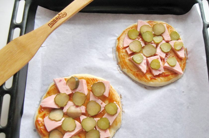 1. Этап. Школьная пицца: Маринованные огурцы нарежьте тонкими кружками и также выложите на пиццу.