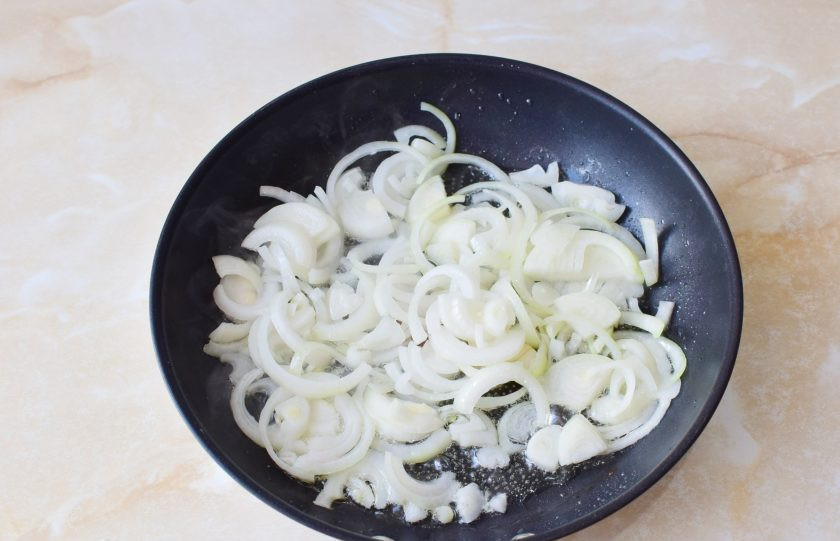 1. Этап. Шампиньоны с луком: В горячую сковороду налейте немного растительного масла и обжарьте лук на небольшом огне 1-2 минуты. Он станет мягче.