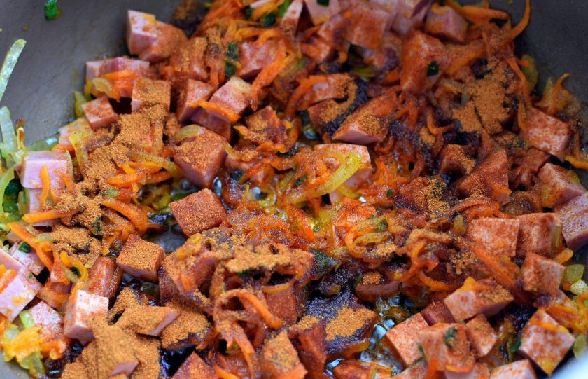 1. Этап. Солянка из свежей и квашеной капусты: Выложите в чашу мультиварки нарезанную некрупными кубиками вареную колбасу и обжарьте до легкой корочки. Посыпьте паприкой и дайте ей окрасить масло в оранжевый цвет.