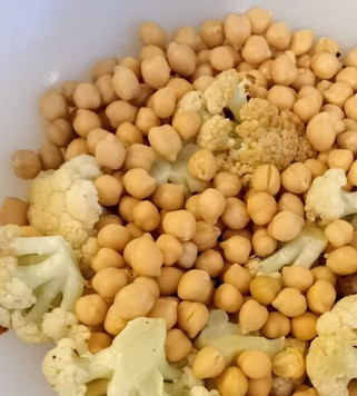 1. Этап. Салат из цветной капусты и нута: Цветную капусту разрезать на половинки. Смазать небольшим количеством оливкового масла, посыпать чайной ложкой соли. Запекать 15-20 минут до золотистости. Затем разделить цветную капусту на небольшие соцветия. Выложить в салатницу и соединить с нутом.