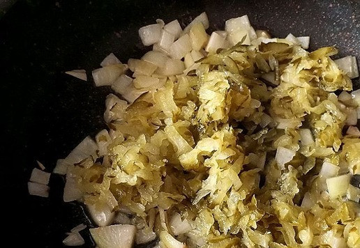 1. Этап. Солянка День 1 января: В этой же сковороде обжариваем немного лук и выкладываем, натёртые на тёрке с зубцами средней величины, солёные огурцы. У меня огурцы кислые бочковые - то, что нужно для этой солянки. Обжариваем немного ещё.