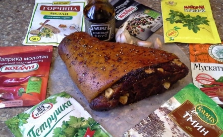 1. Этап. Запекание свиной рульки в духовке: Затем ножом делаем в рульке небольшие проколы и вставляем в них дольки очищенного чеснока. В миске смешиваем все сухие специи, соль и соевый соус, намазываем рульку со всех сторон этим маринадом. Оставляем мариноваться мясо на ночь в холодильнике.