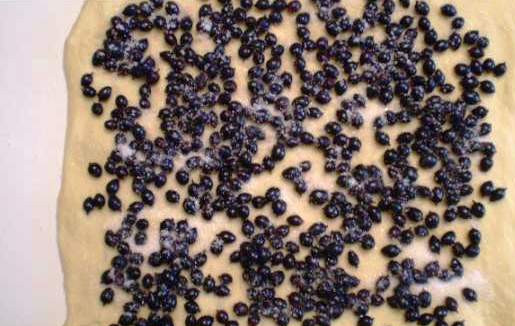 1. Этап. Рулет со смородиной: На тесто выложите смородину, присыпьте сахаром и сверните рулет.