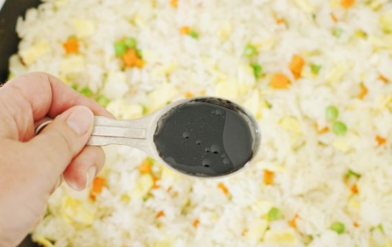 1. Этап. Отварной рис с омлетом и овощами: 5. Выложите на сковороду рис. Добавьте соль, перец, соевый соус и другие специи по желанию.