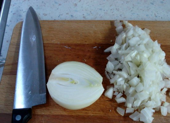 1. Этап. Бигус с черносливом: Пока мясо жарится, чистим и нарезаем репчатый лук, затем выкладываем его на сковороду к телятине, продолжаем все жарить, пока лук не станет золотистым.