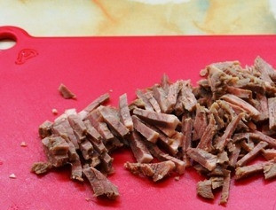 1. Этап. Салат из свежей капусты с зеленым горошком: Нарежьте соломкой заранее отваренную говядину, отправьте мясо к капусте.