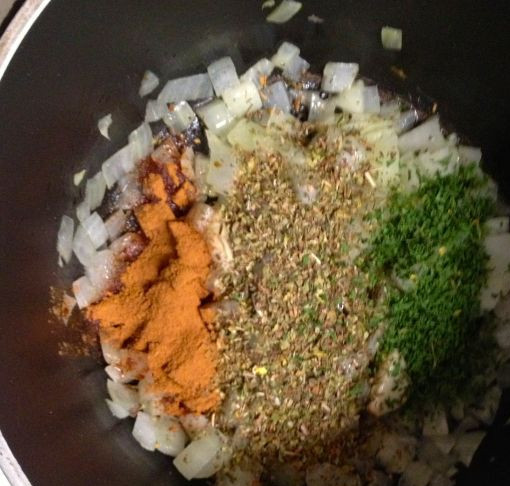 1. Этап. Мусака вегетарианская: Добавляем к луку орегано, корицу, тимьян, мелко нарубленную петрушку и перемешиваем.