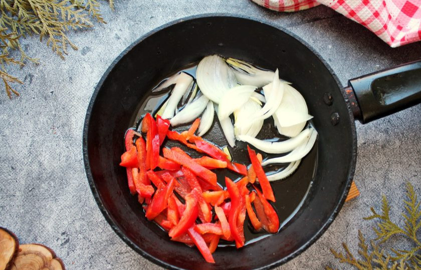 1. Этап. Ропа вьеха: В сковороду с толстым дном налейте растительное масло и разогрейте на сильном огне. Выложите в сковороду репчатый лук порезанный полукольцами и болгарский перец соломкой. Обжаривайте все в течение 5-8 минут, перемешивая.