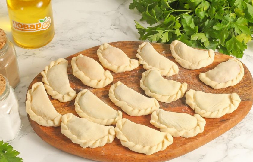 1. Этап. Вареники с сюрпризами на Старый Новый год: Защипните края и сделайте фигурный шов, понемногу защипывая в одну сторону. Начинки символизируют: семечки — новые замыслы и планы, мандарин — наслаждение, киви — соблазн, шкварки — богатство, мясо — сытую жизнь, огурец — сильного мужчину, томаты — искушение, тертый картофель — повышение по работе, сыр — выигрыш.