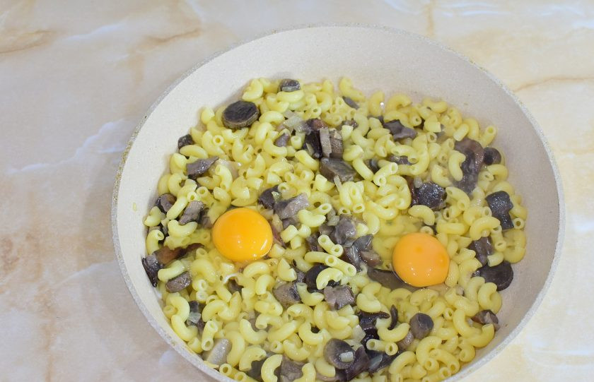 1. Этап. Макароны с грибами и яйцом: Выложите к грибам отварные макароны и добавьте яйца. Все перемешайте.