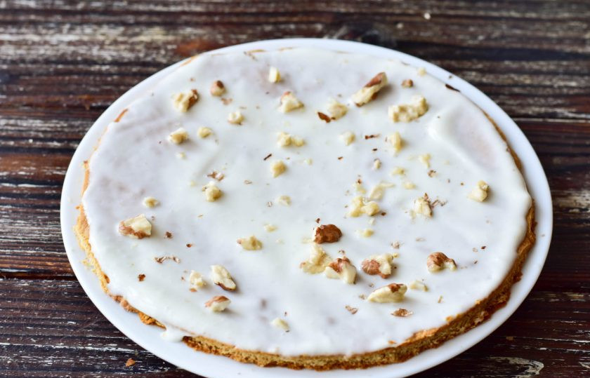 1. Этап. Медовик с орехами: Полученным кремом смажьте все испеченные коржи. Только предварительно обрежьте неровные края, используя для этого тарелку. Сверху на каждый корж выложите измельченные грецкие орешки.