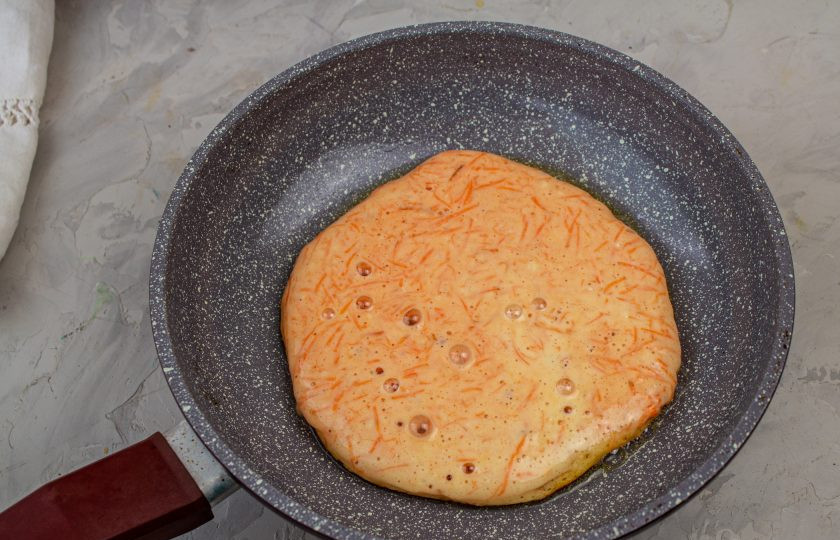 1. Этап. Торт морковный на сковороде: Разогретую сковороду смазываем растительным маслом (используя примерно 1 ч. ложку). Выливаем 1/4 часть теста на сковороду и жарим с одной стороны под крышкой 2-3 минуты.