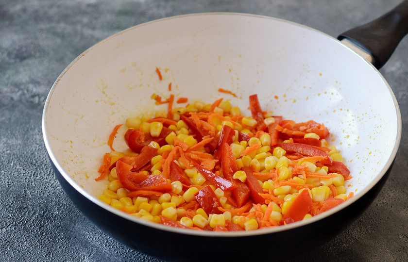 1. Этап. Рис с тофу и овощами: Болгарский перец нарежьте соломкой, морковь натрите на терке. Обжарьте перец, морковь и кукурузу на среднем огне 4-5 минут.