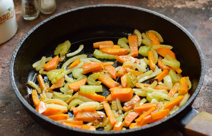 1. Этап. Куриная печень с сельдереем: В сковороде прогрейте растительное масло, выложите лук, морковь и сельдерей. Жарьте овощи 4 минуты.