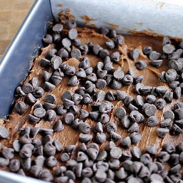 1. Этап. Шоколадные пирожные с орехами и суфле: 4. Выложить тесто в подготовленную форму. Посыпать шоколадными чипсами. Запекать в разогретой духовке в течение 22-25 минут.