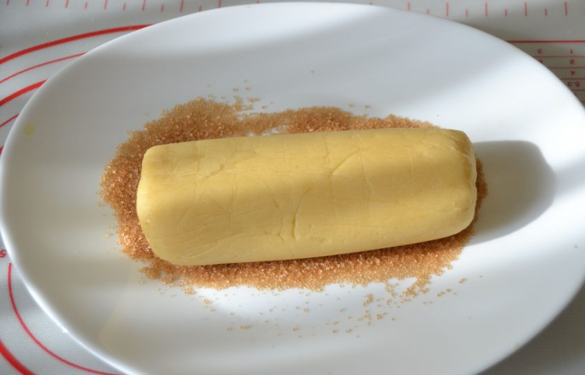 1. Этап. Бретонское песочное тесто: Насыпьте на тарелку коричневый тростниковый сахар, обваляйте в нем тесто со всех сторон.